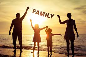 A happy family standing by the beach during sunset, Parents holding the word Family above the kids divorces in florida