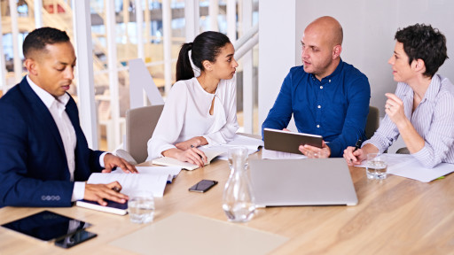 Young diverse and dynamic group of eclectic multiethnic individual business people busy conducting a meeting in a modern office conference room with several electronic devices at their disposal mediated divorce