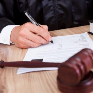 Male Judge Writing On Paper In Courtroom attorney for divorce