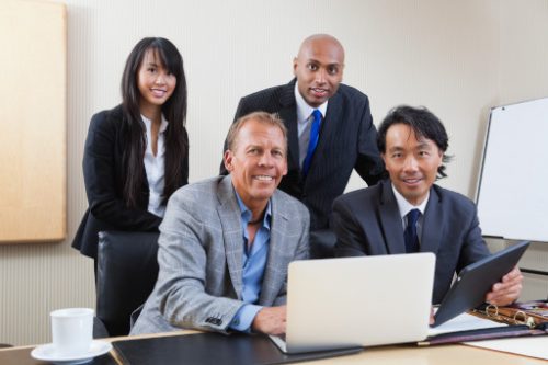 Portrait of multi ethnic businesspeople in office smiling looking at the camera post marital agreements